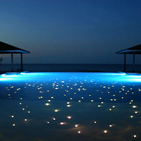 End emitting fiber optic lighting providing point illumination from bottom of swimming pool